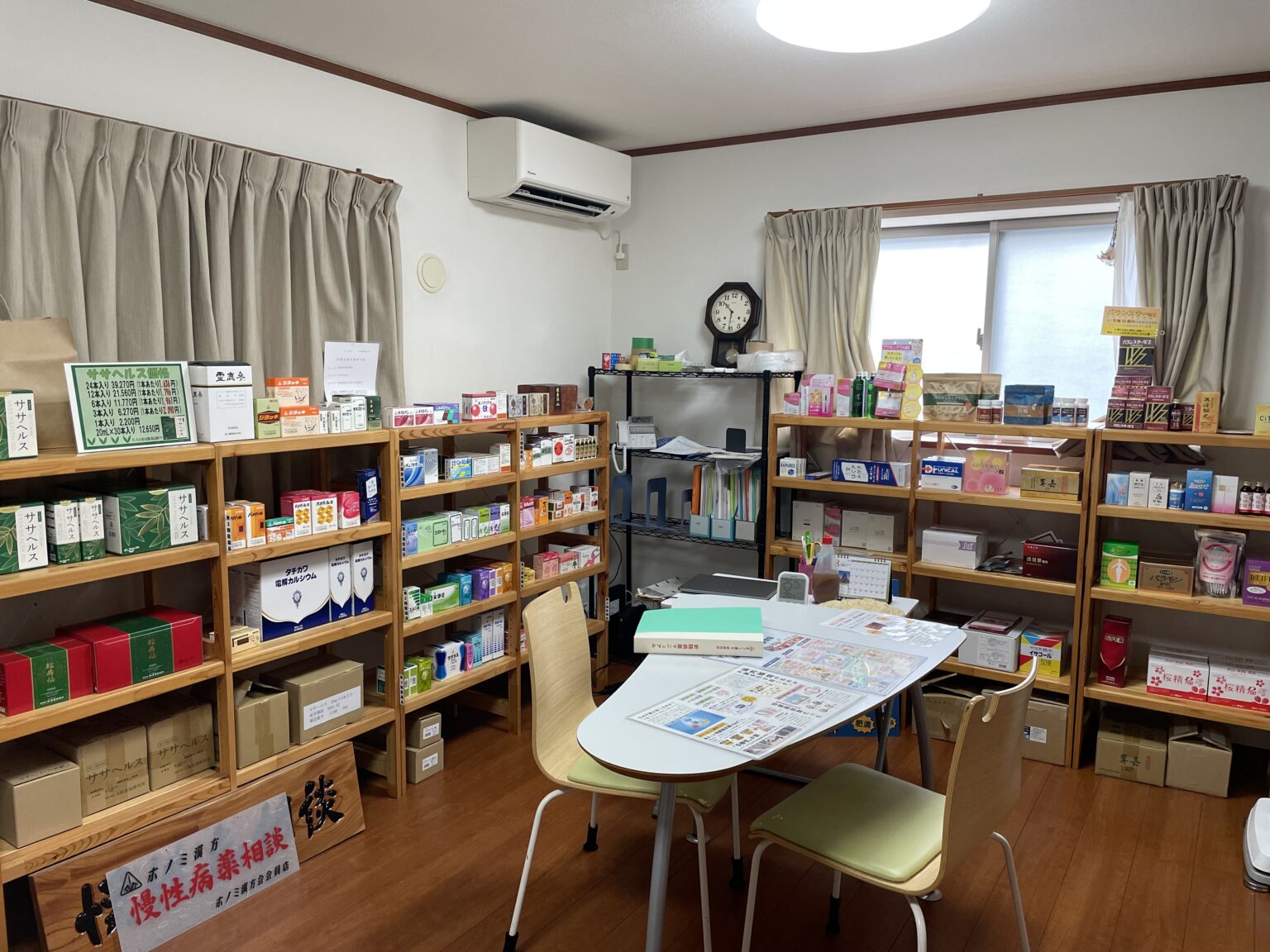 くすりのすみれ仮店舗の店内。漢方薬や健康食品の棚と、座って話せる相談テーブル